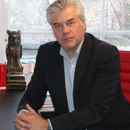 Portret van strafrechtadvocaat mr. John Peters aan zijn bureau